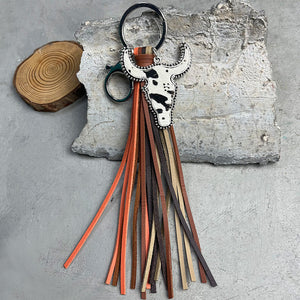 Cowhide horn keyring with black spots and multi-colored leather fringe.