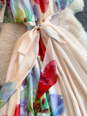 Off-shoulder A-line dress in light pink with a vibrant floral print and belted waist.