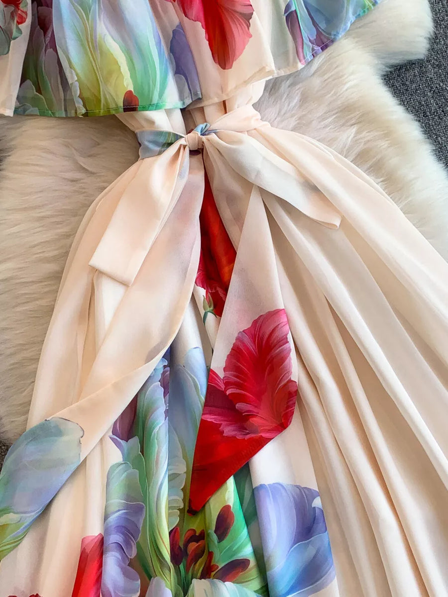 Off-shoulder A-line dress in light pink with a vibrant floral print and belted waist.