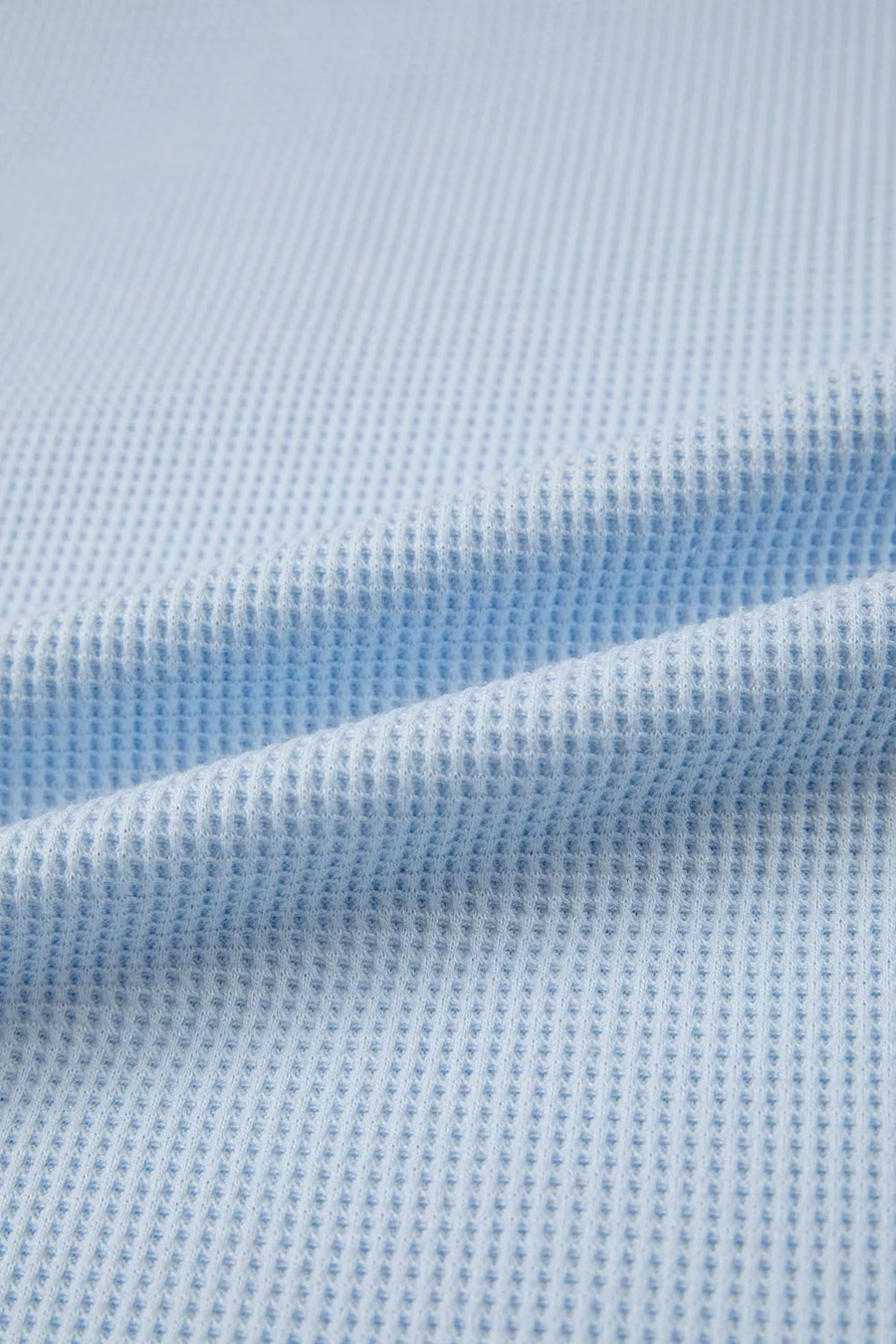 Light blue waffle knit polyester t-shirt with a textured pattern and curved hem detail.