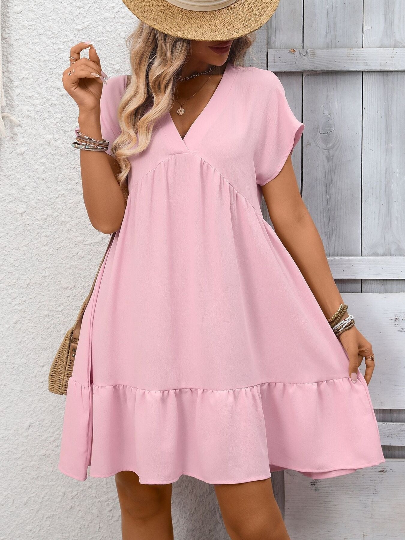 Pink V-neck mini dress with short sleeves and a ruffled hem.