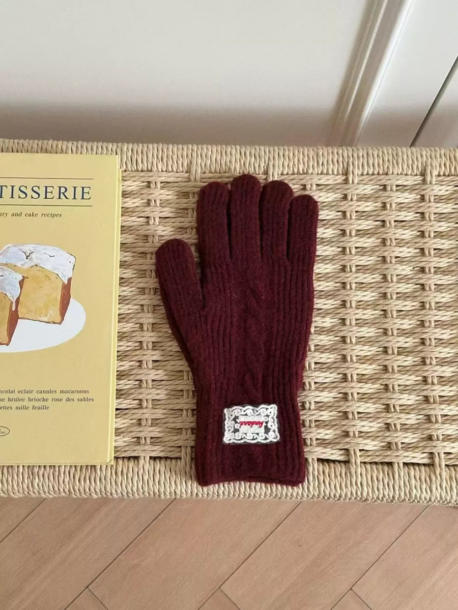 Burgundy cable knit acrylic gloves with decorative patch detail.