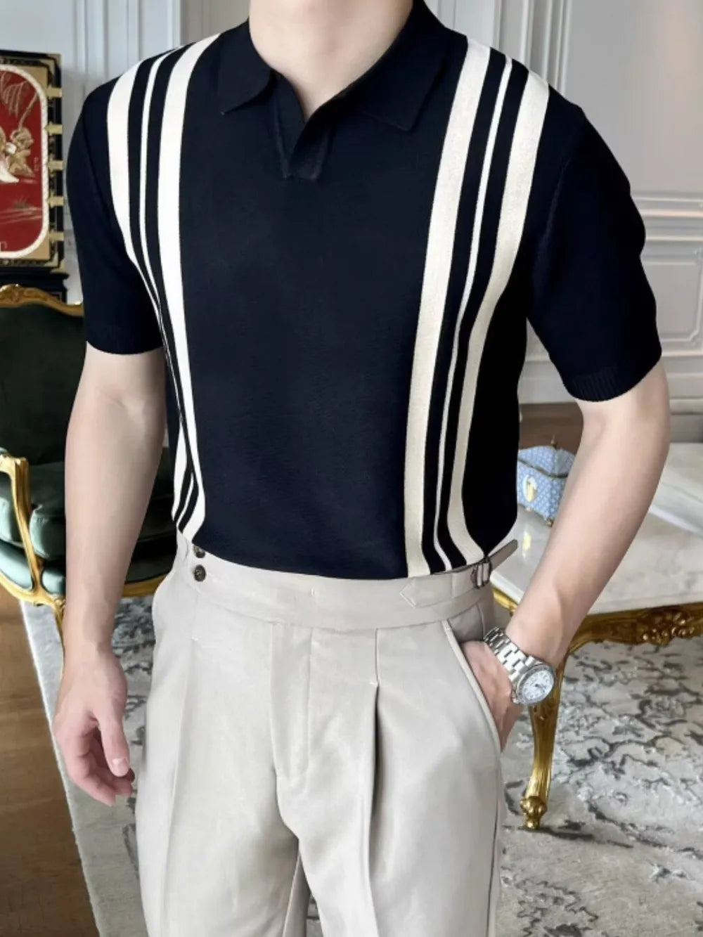 Black and ivory vertical stripe knit polo shirt with short sleeves and a spread collar.