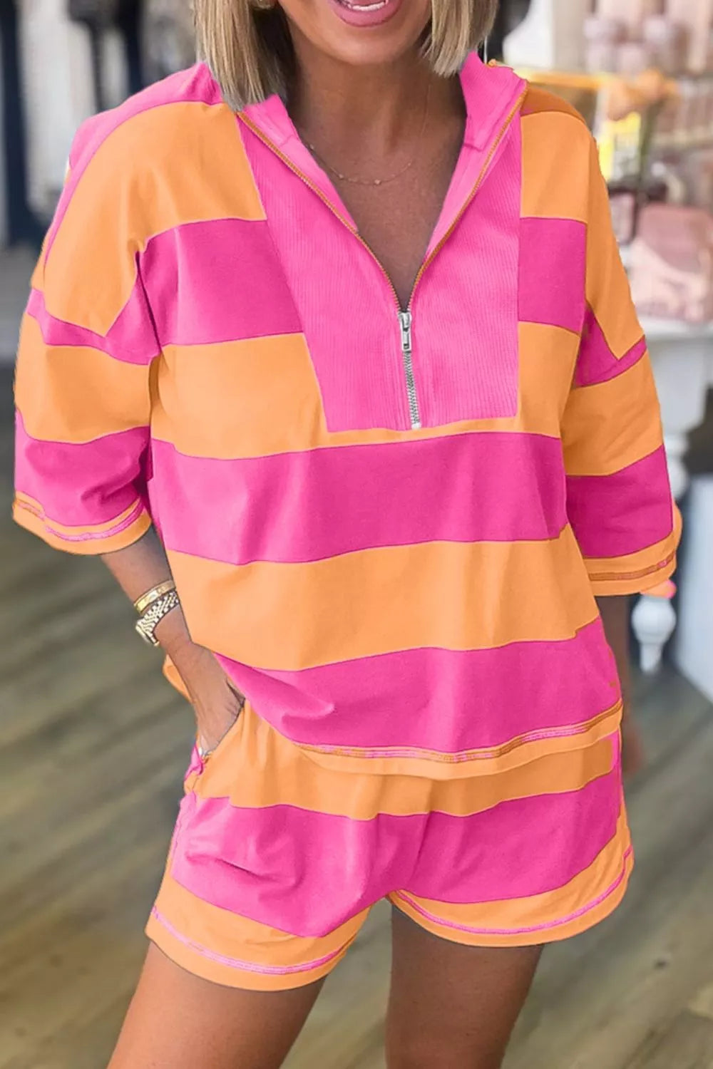 Pink and orange striped two-piece set with drawstring shorts and quarter-zip hoodie.