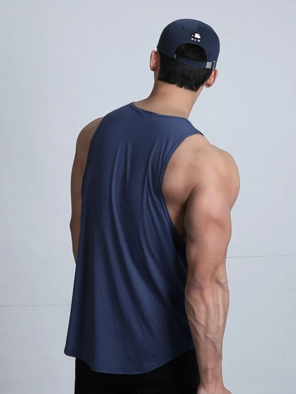Navy performance cut tank top with a rounded hem, shown from the back.
