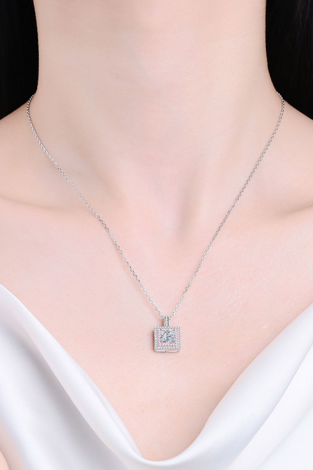 Silver moissanite halo pendant necklace with a square-cut center stone and pave-set accent stones.