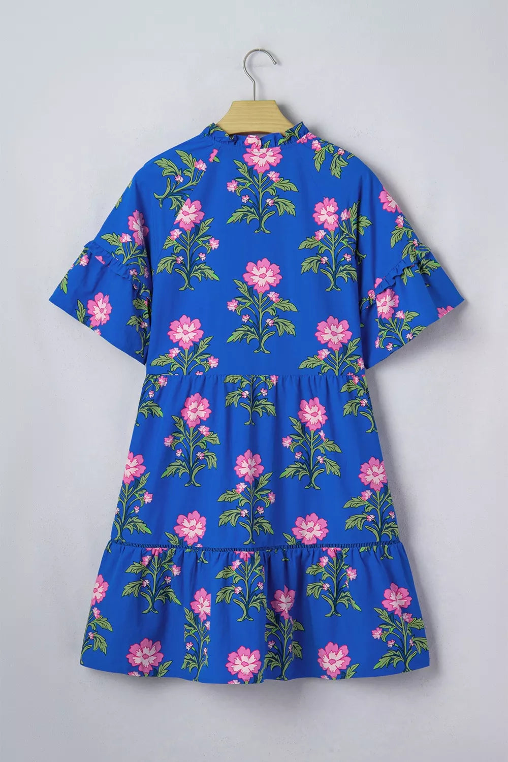 Blue tiered cotton dress with pink floral print, ruffled neckline and sleeves.