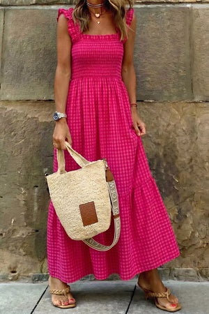 Charming pink gingham cotton sundress with smocked bodice and ruffled straps.