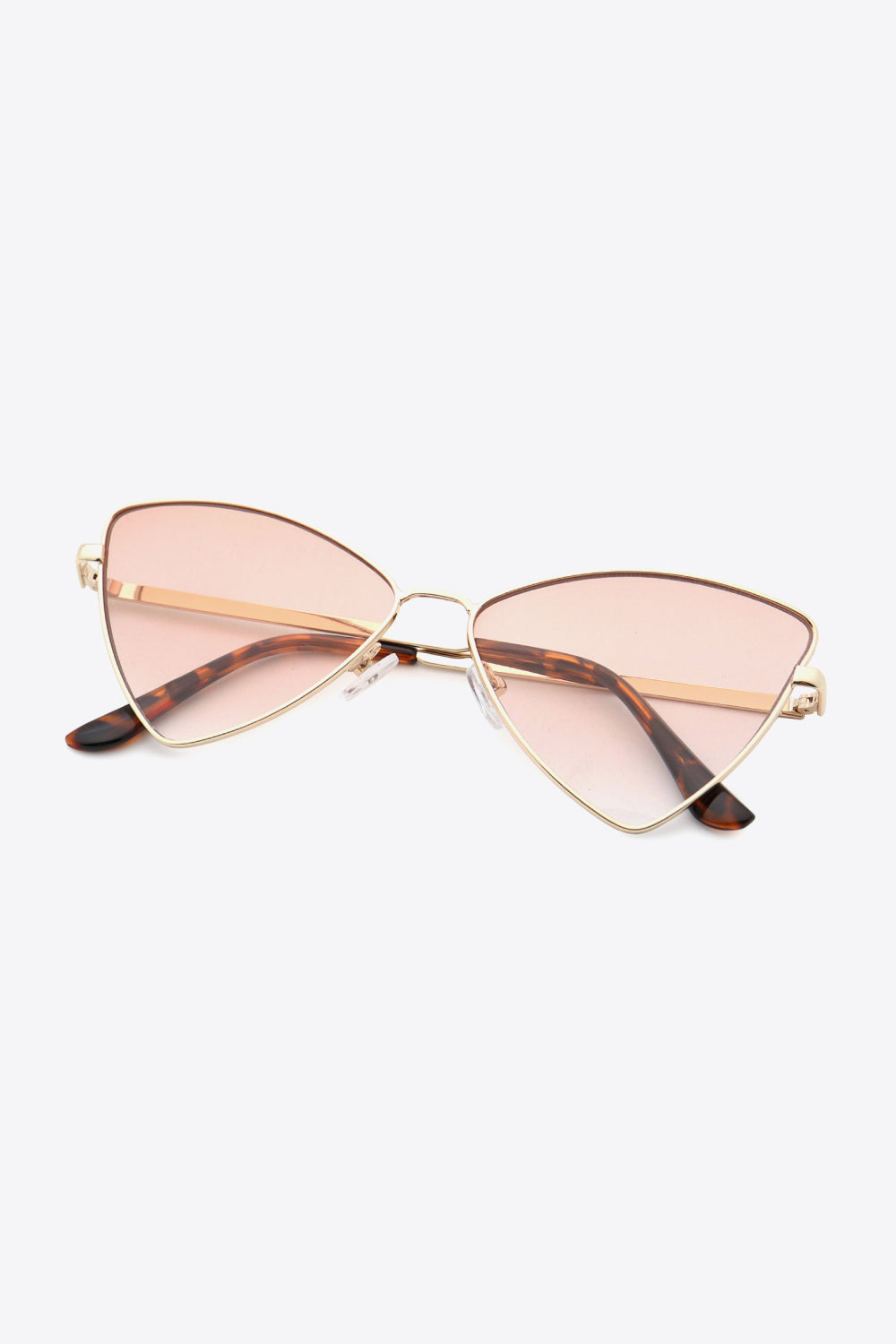 Angular cat-eye sunglasses with gold frames and gradient pink lenses.