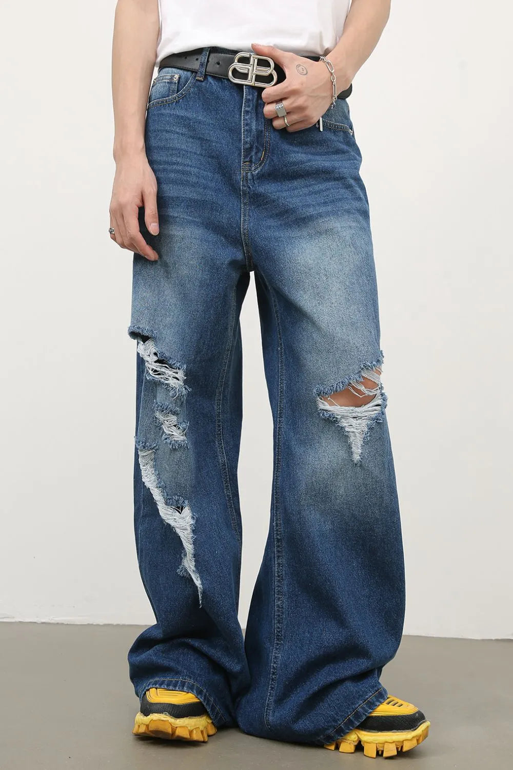 Distressed palazzo jeans in medium wash denim with ripped details and a wide leg.