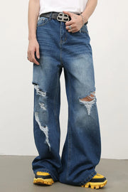 Distressed palazzo jeans in medium wash denim with ripped details and a wide leg.