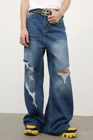 Distressed palazzo jeans in medium wash denim with ripped details and a wide leg.