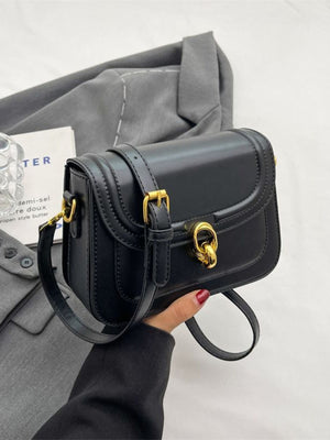 Black pu leather flap crossbody bag with gold hardware and adjustable strap.