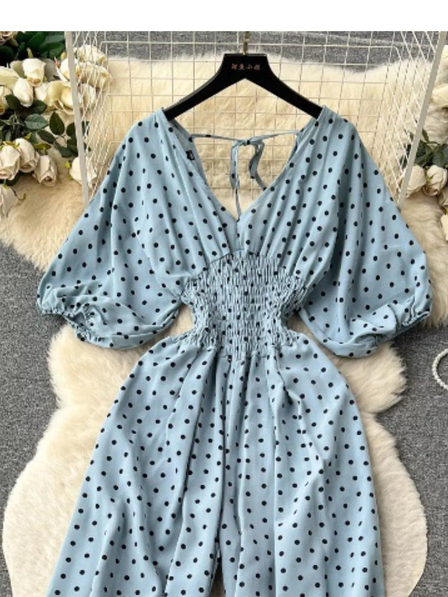 Light Blue polka dot smocked wide-leg romper with V-neck and tie back.