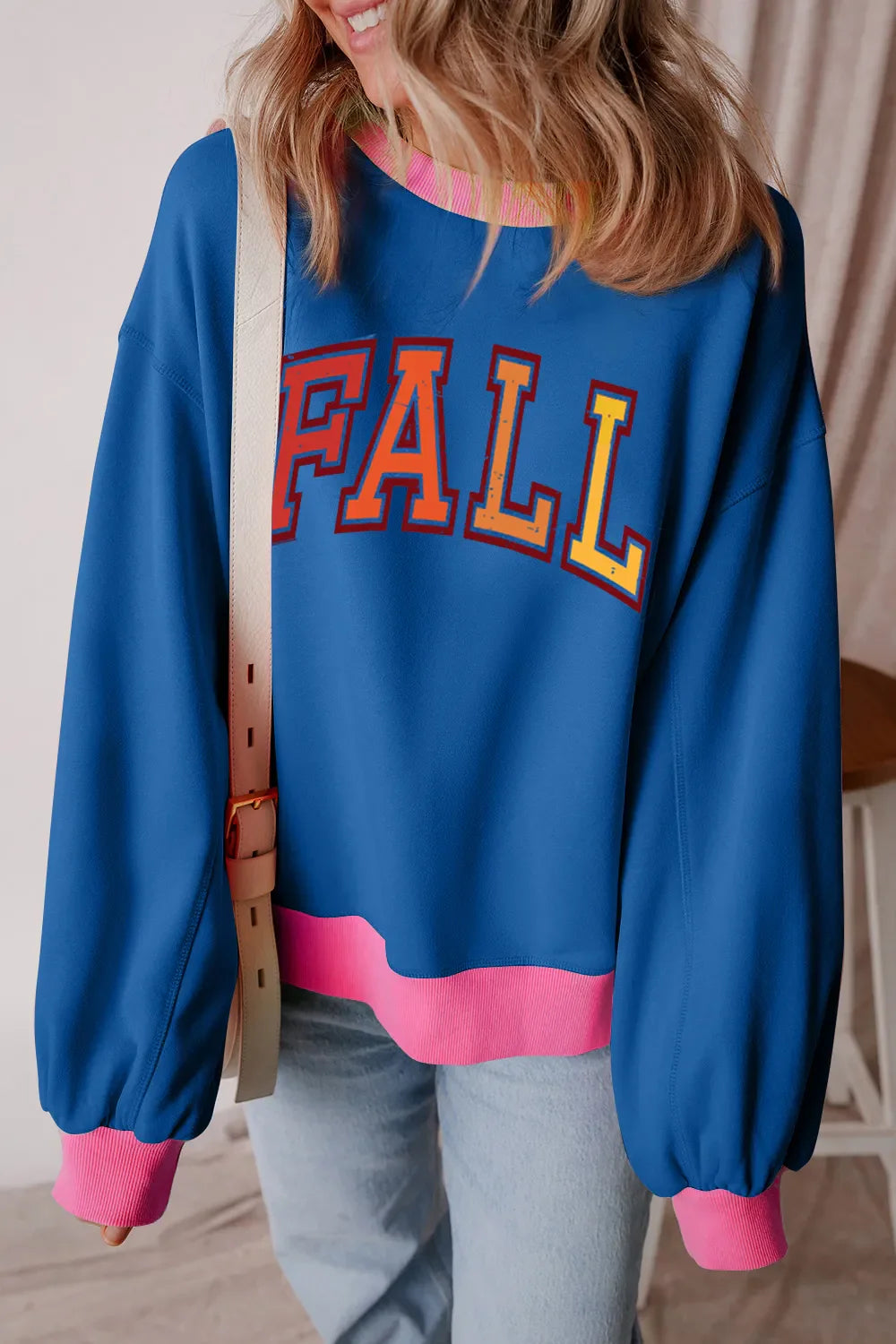 Peacock blue sweatshirt with "FALL" graphic, pink trim, and crew neck.
