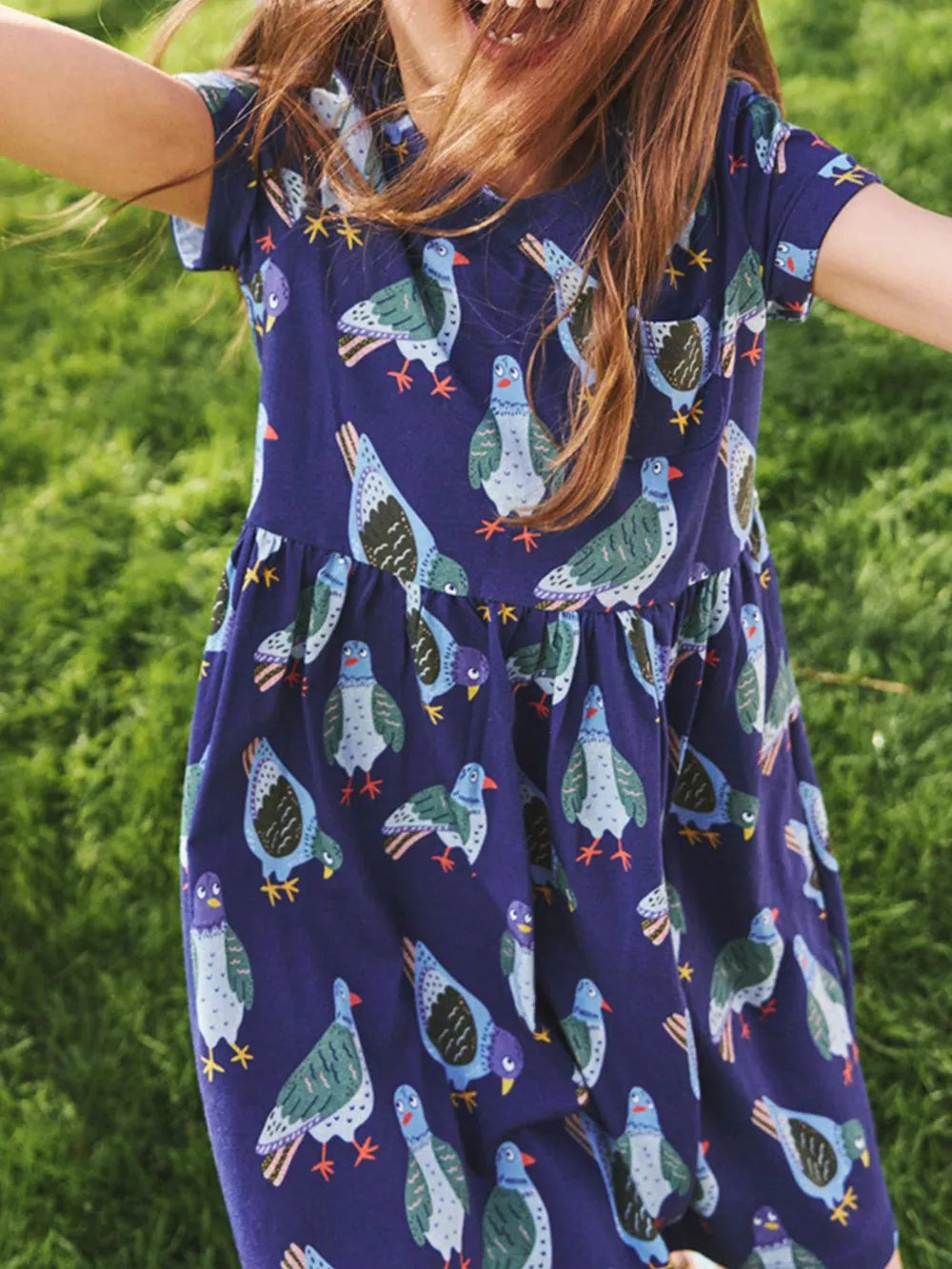 Navy blue cotton toddler dress with playful pigeon print, short sleeves, and gathered skirt.