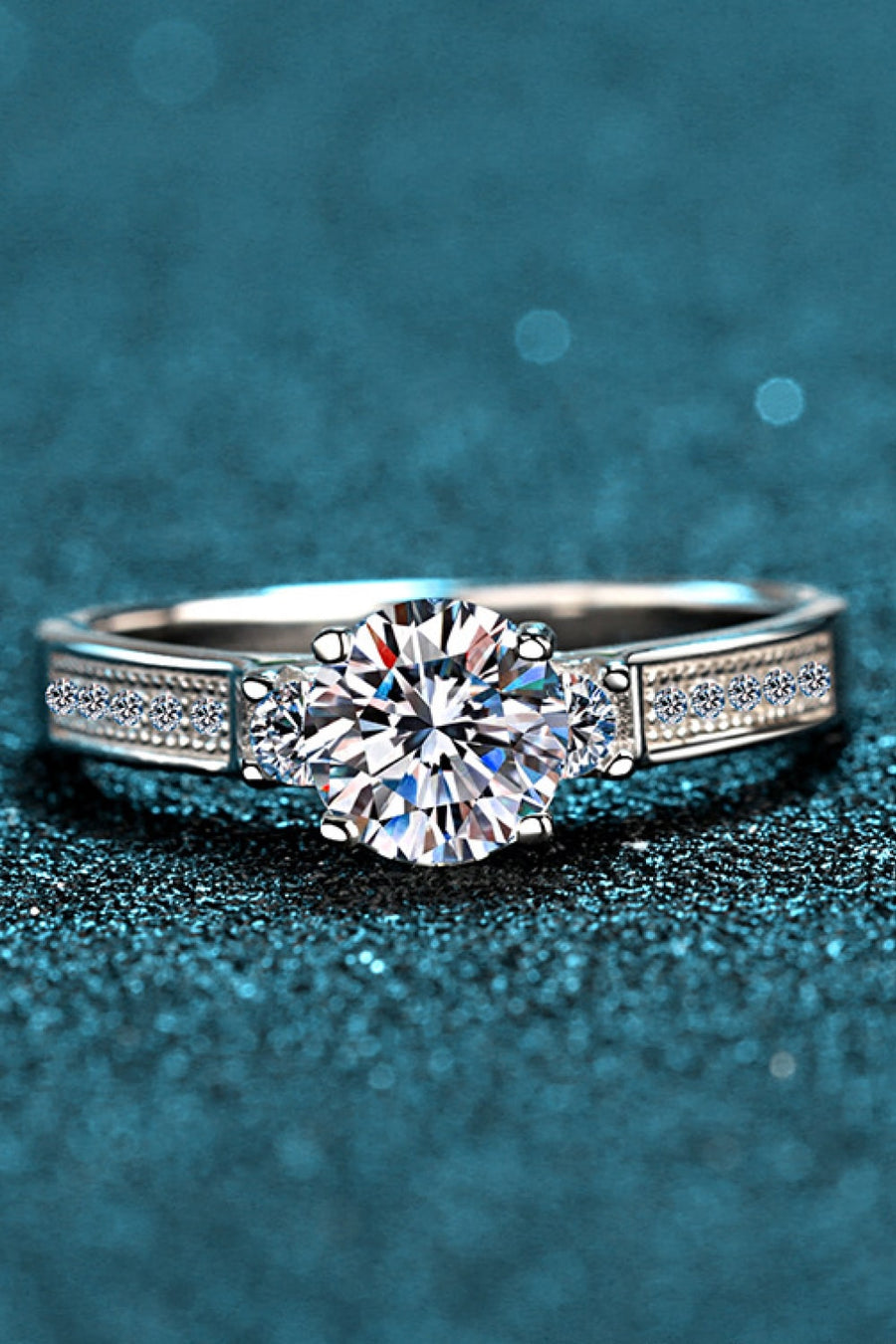 Silver rhodium engagement ring with pavé band and solitaire center stone.