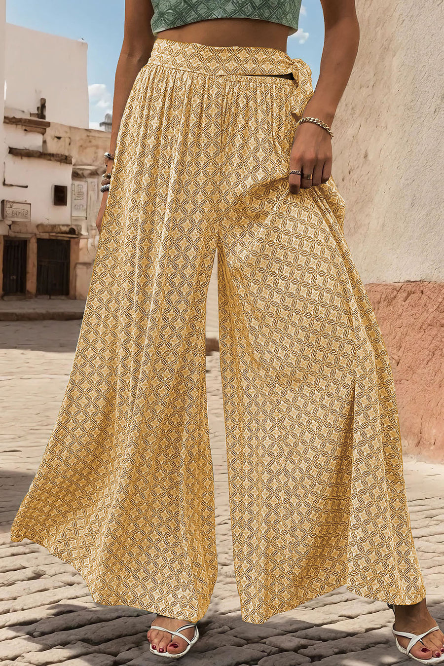 Yellow geometric print wide-leg palazzo trousers with a tie waist and side slits.