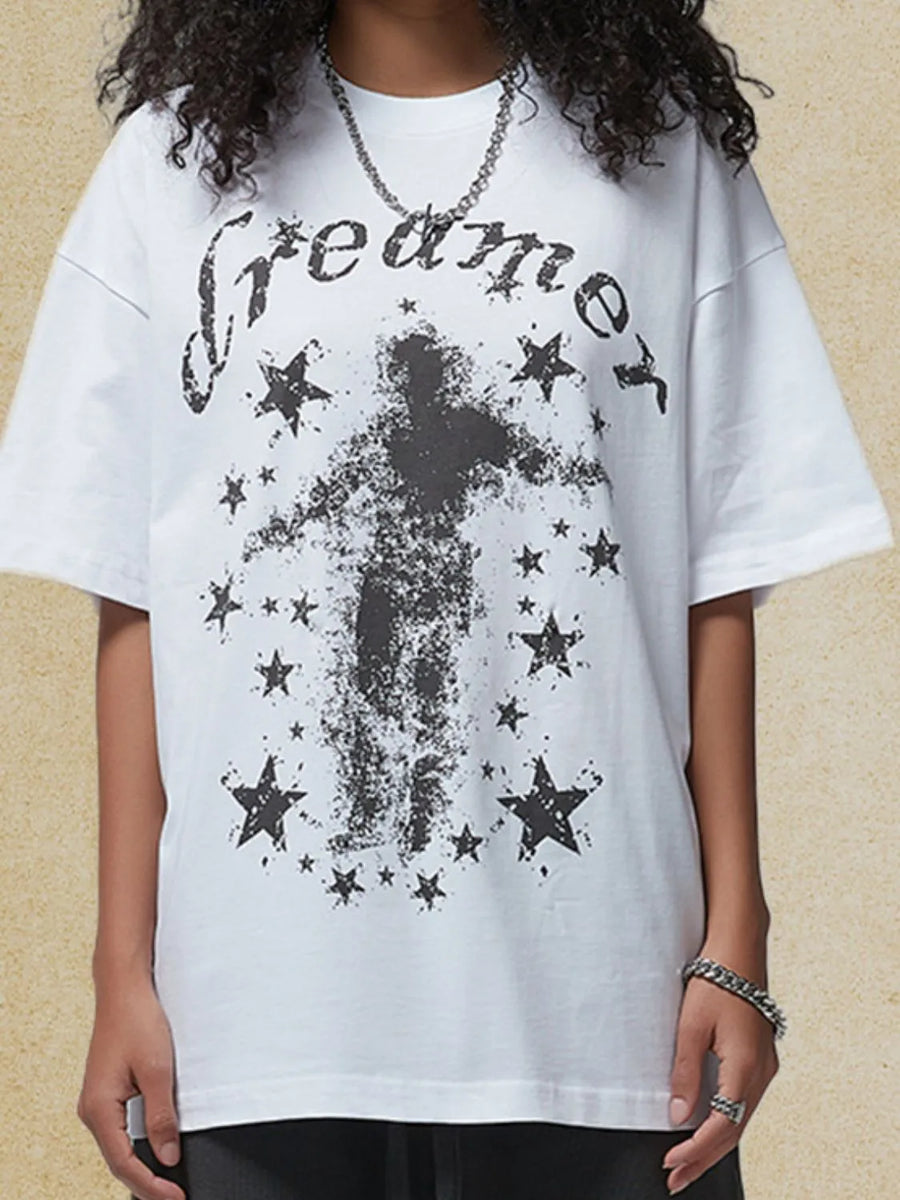 White graphic t-shirt with black "dreamer" text and a distressed figure surrounded by stars.