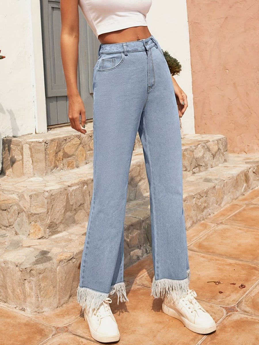 Light wash denim flare jeans with a fringed hem.