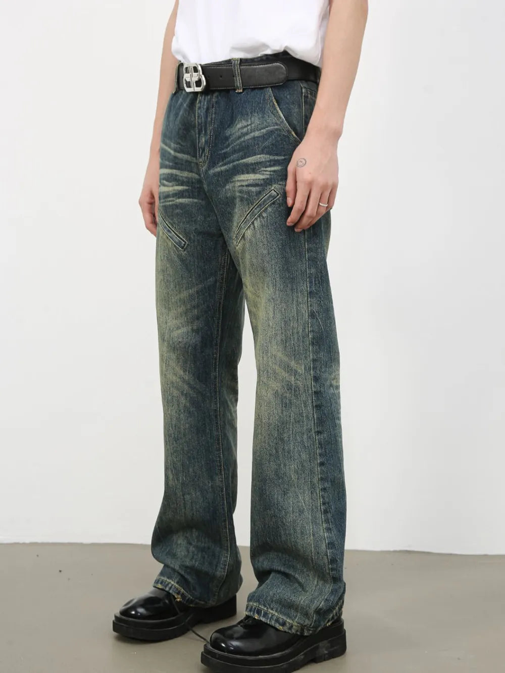 Vintage wash flare leg jeans in medium blue denim with whiskering and distressed details.