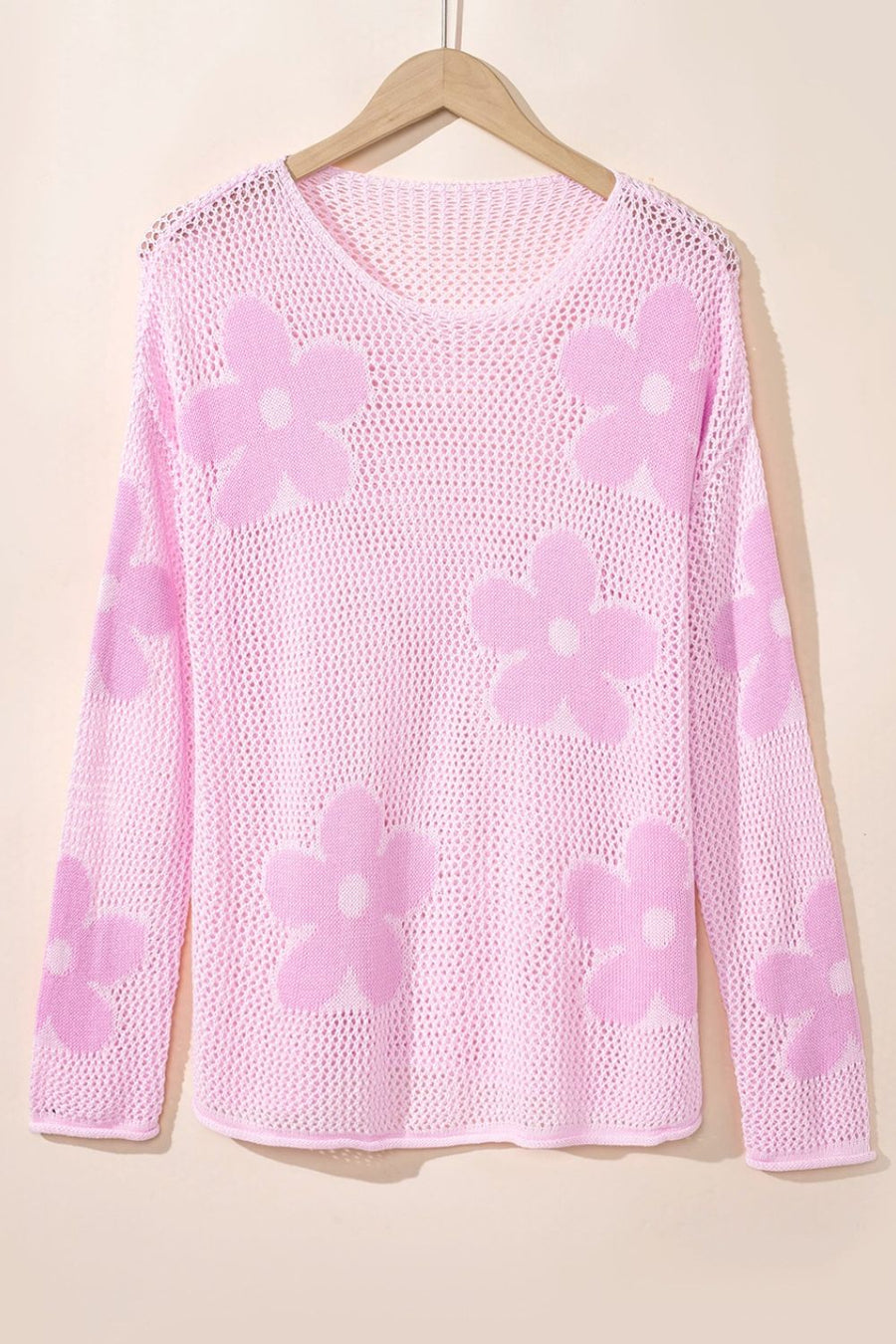 Openwork floral intarsia sweater in blush pink acrylic with a v-neck and long sleeves.