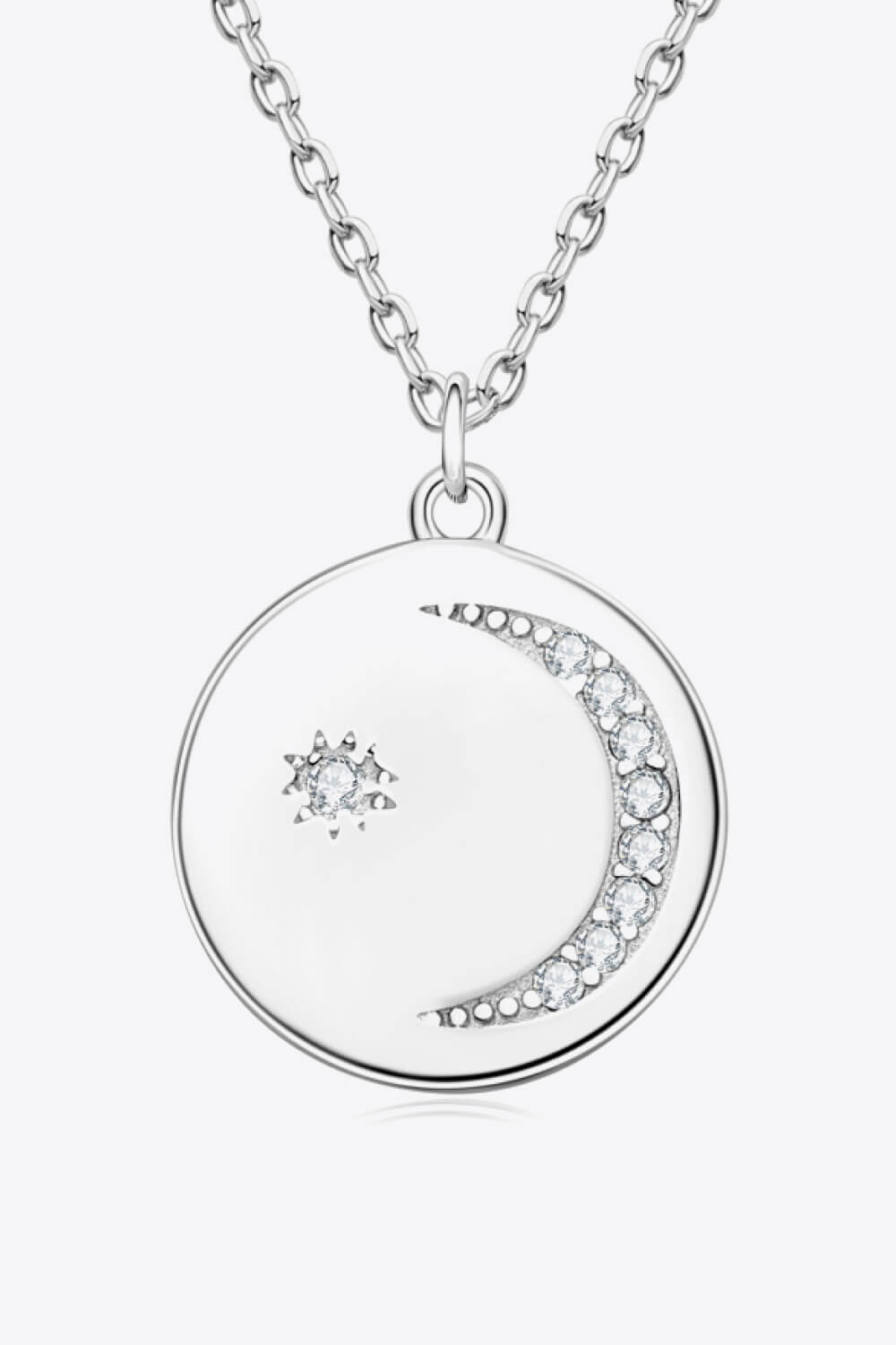 Silver necklace with round pendant featuring a crescent moon and star charm with crystals
