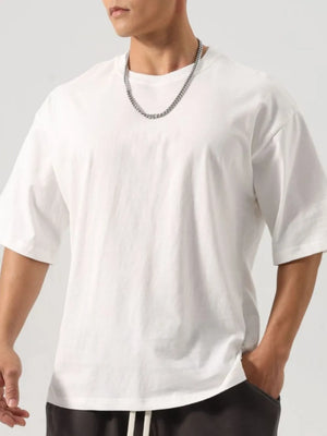 White washed cotton t-shirt with boxy cut and crew neck, styled with a chain necklace.