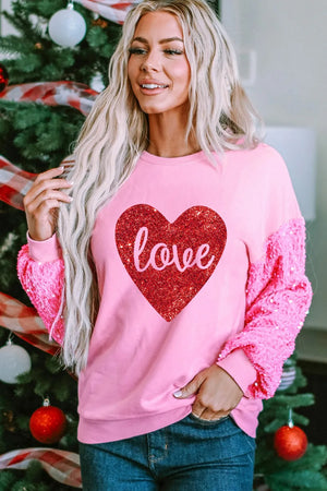 Pink sweatshirt with sequin sleeves and a red glitter heart graphic that says "love".