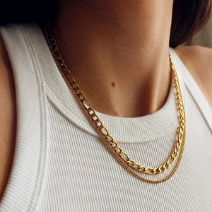 Dual-strand gold curb chain necklace layered over a white tank top.