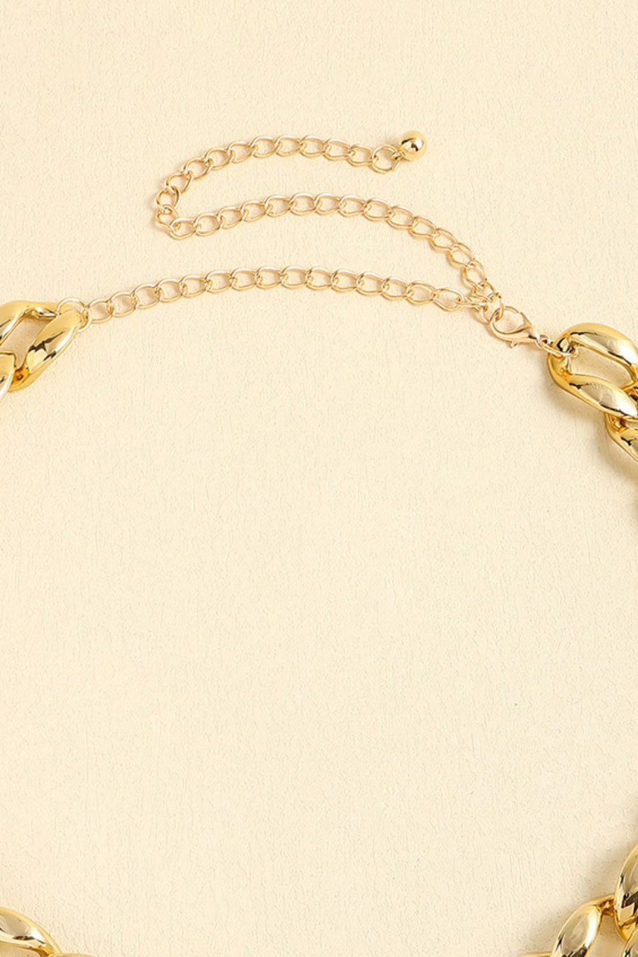 Chunky gold-tone curb chain necklace with extender chain and lobster clasp closure.