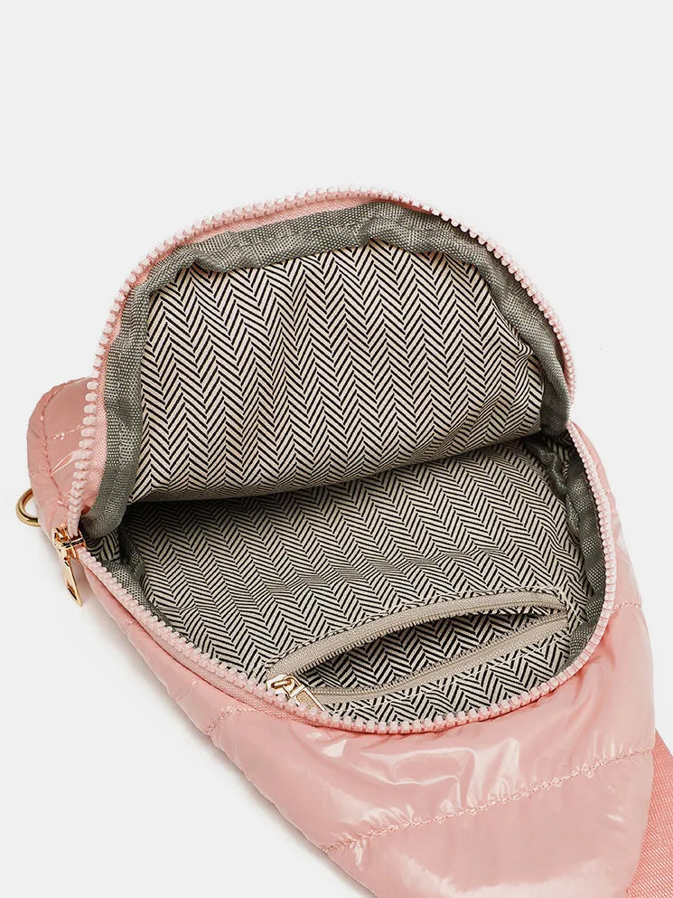 Pink glossy padded sling bag interior with chevron pattern lining and zippered pockets