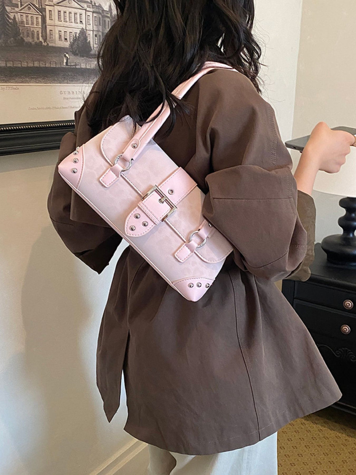 black shoulder bag featuring buckle detail and leopard