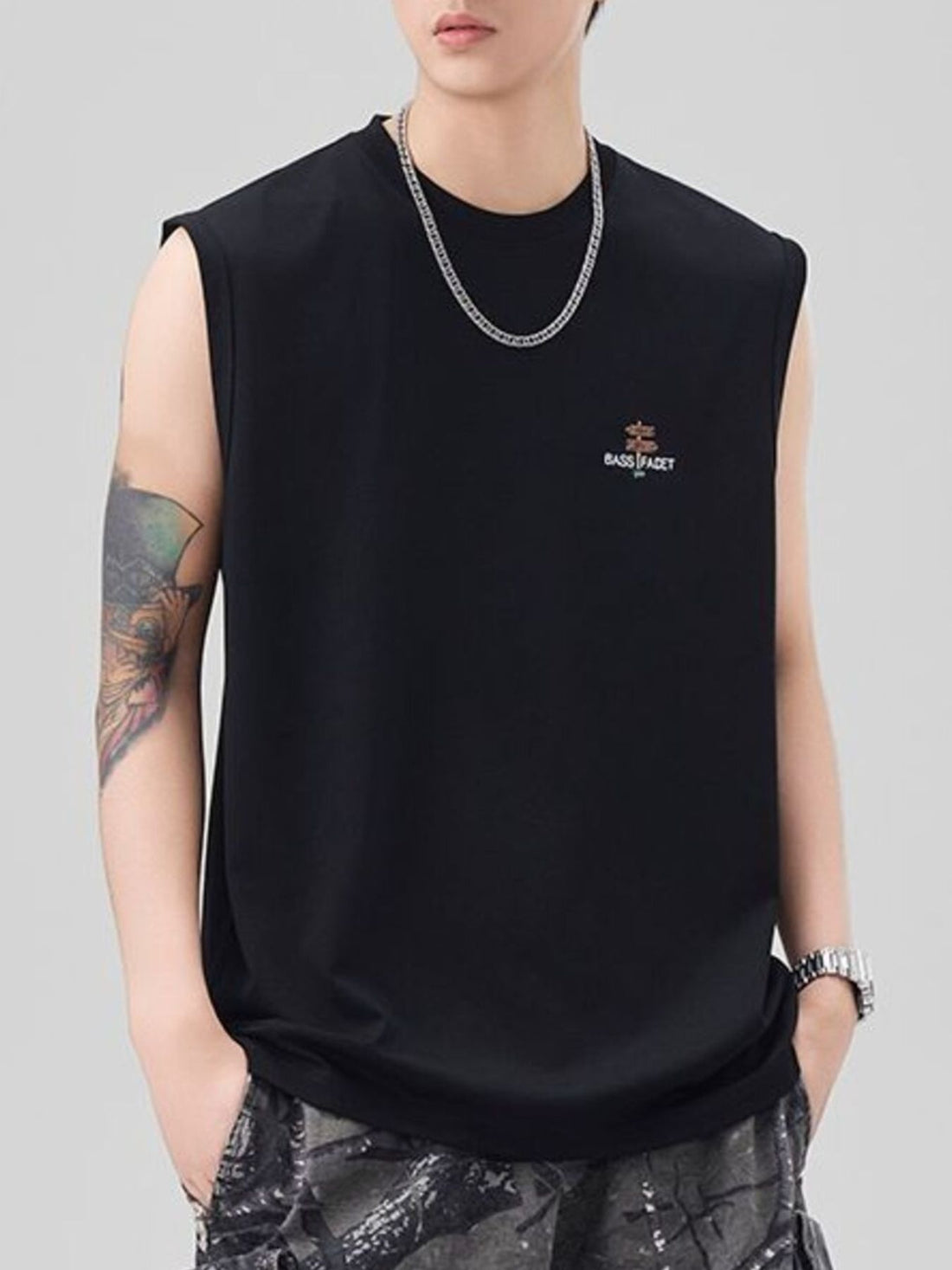Men's black oversized cotton tank top with small chest logo detail.