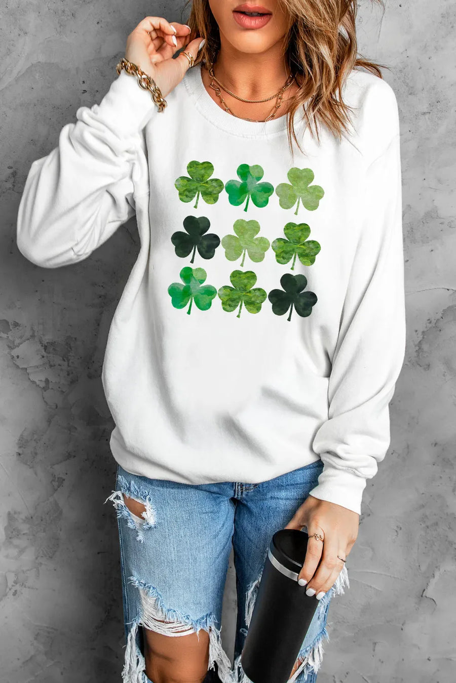 White crewneck sweatshirt with a grid of green watercolor shamrock prints.