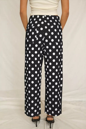 Black polka dot wide leg trousers with pockets and a mid-rise waist.