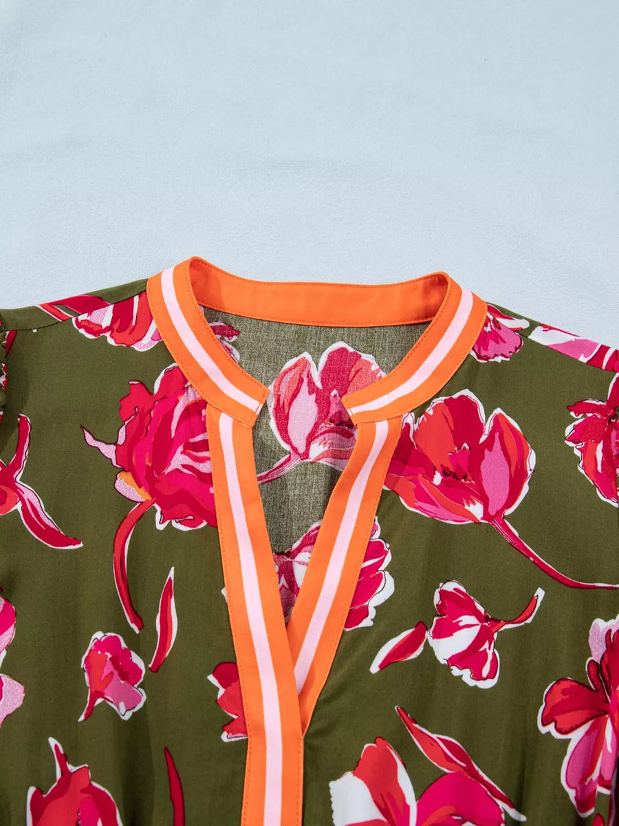 Print split neck dress with floral pattern and orange trim.