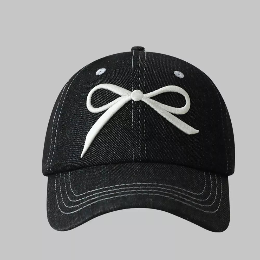 Black baseball cap with white embroidered bow accent