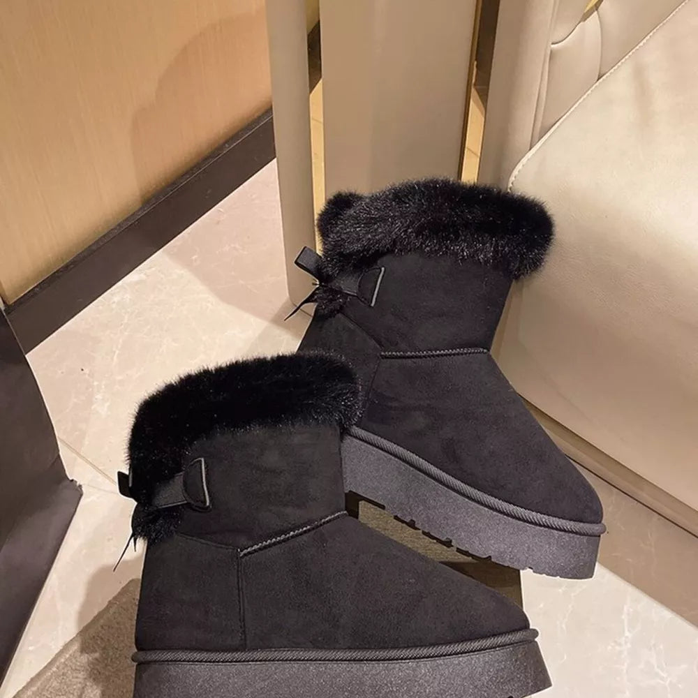 Black suede round-toe boots with fur trim and bow detail.