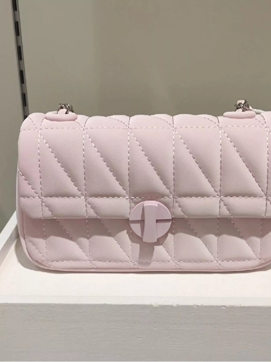 Pink quilted flap chain bag with a turn-lock closure.