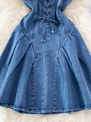 Blue denim A-line dress with lace-up corset detail and tie waist.