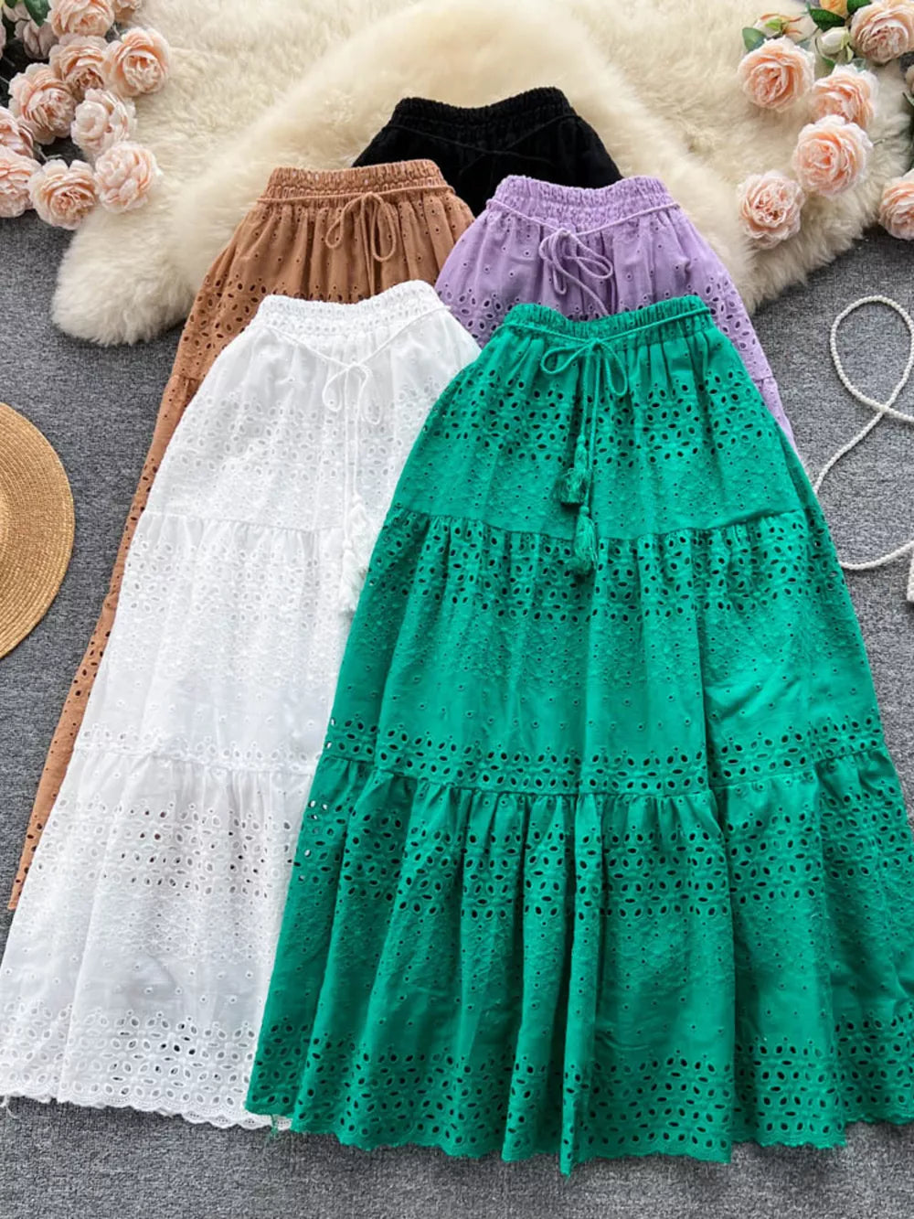 Delicate eyelet tiered maxi skirt with drawstring waist in green, white, light brown, purple, and black.