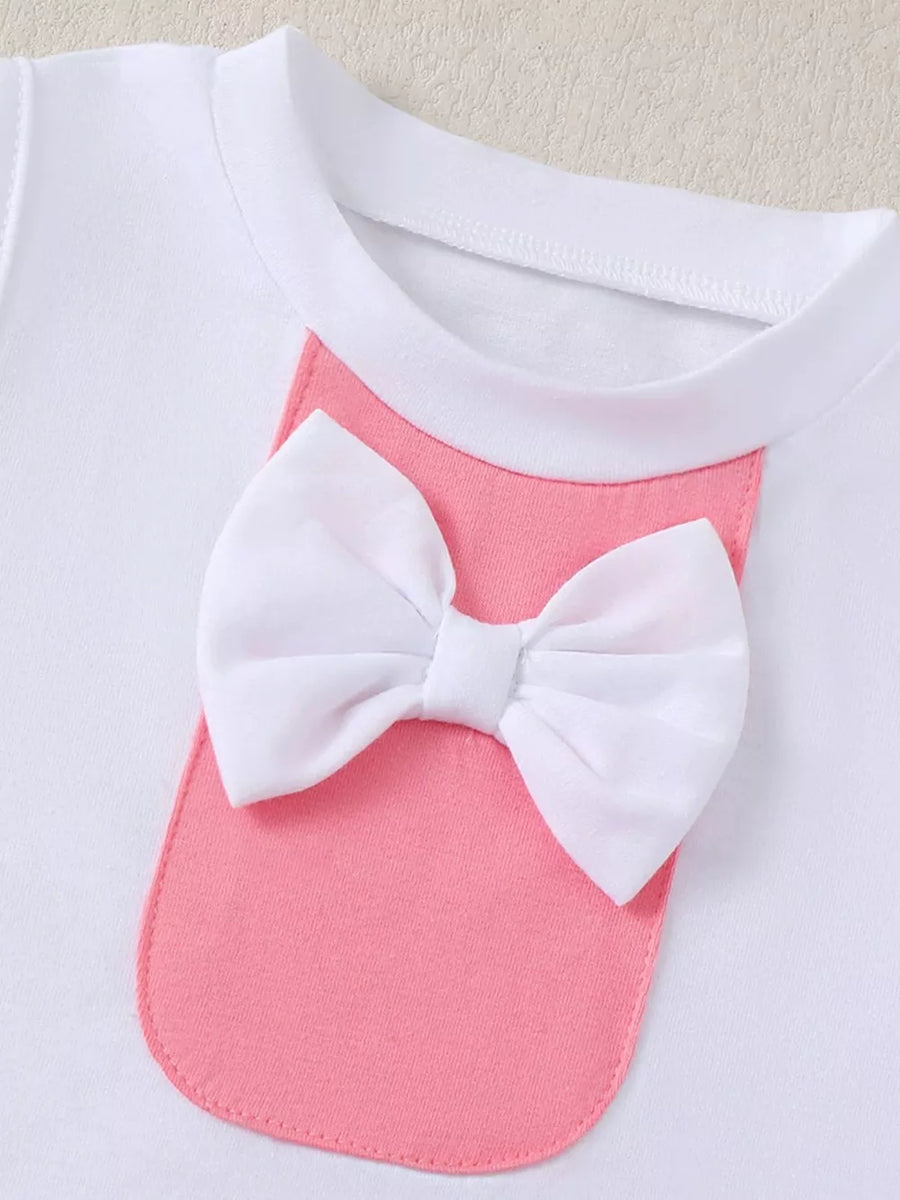 White cotton baby top with pink pocket and white bow detail.
