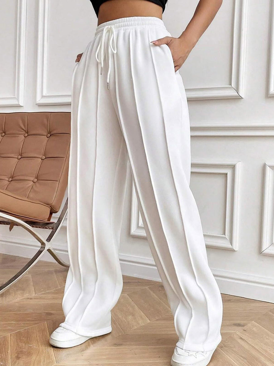 White pleated palazzo trousers with drawstring waist and wide legs.