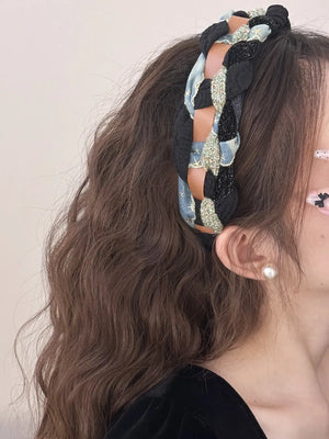 Braided headband with black, blue, and brown leatherette details and starburst pattern.