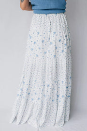 Bohemian tiered maxi skirt with blue floral print on white fabric.