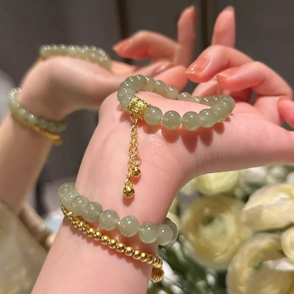 Delicate 18k gold-plated bead bracelet with green jade-like beads and gold charm.