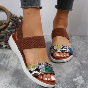 Geometric print elastic strap sandals with brown elastic bands and white soles.