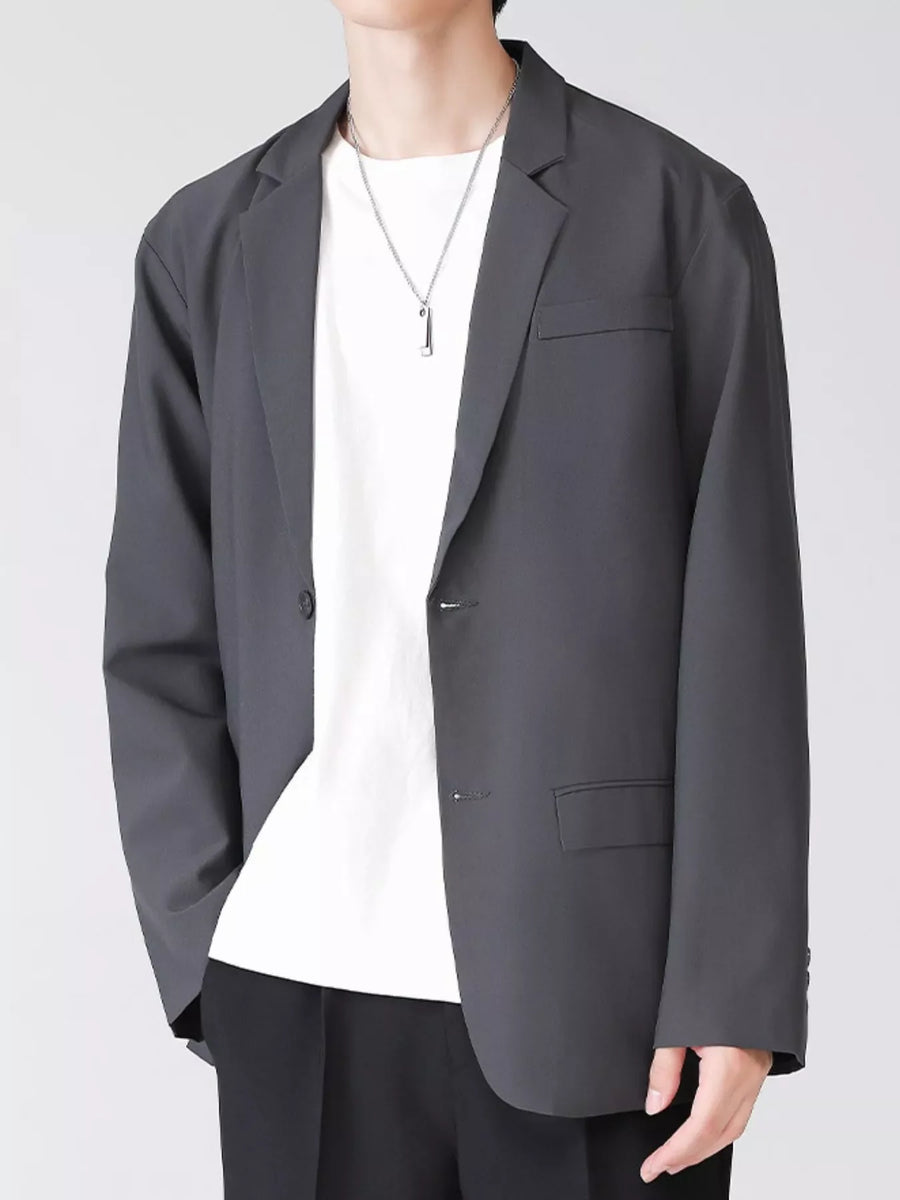 Men's grey lapel collar button up blazer with two buttons and a chest pocket.