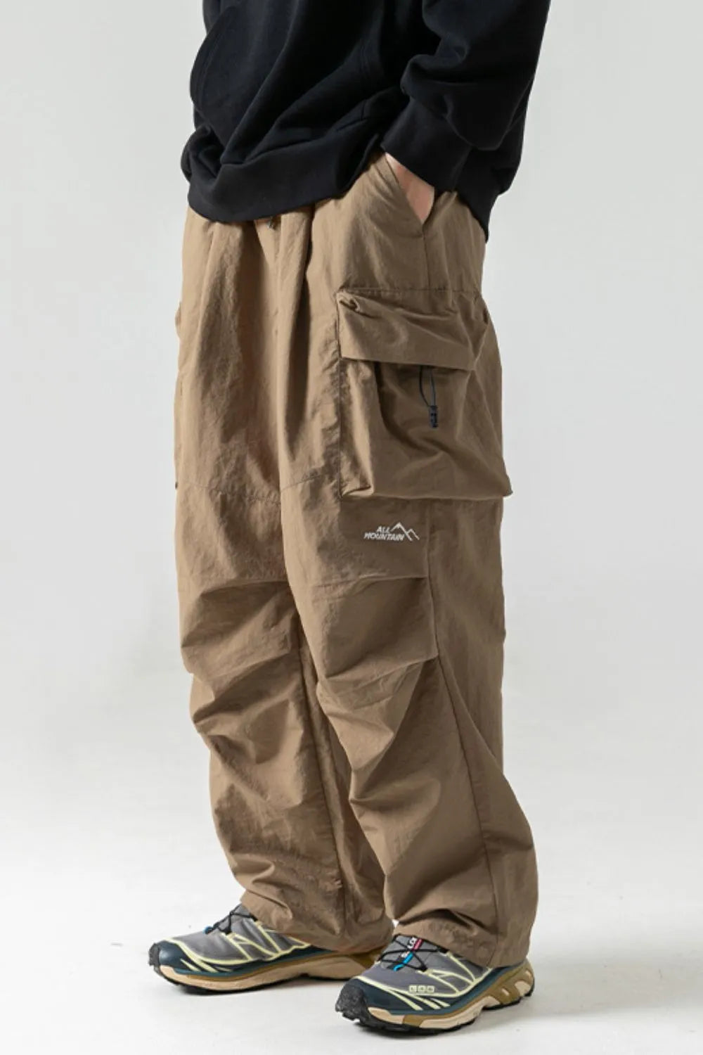 Khaki oversized cargo pants with multiple pockets and a drawstring detail.